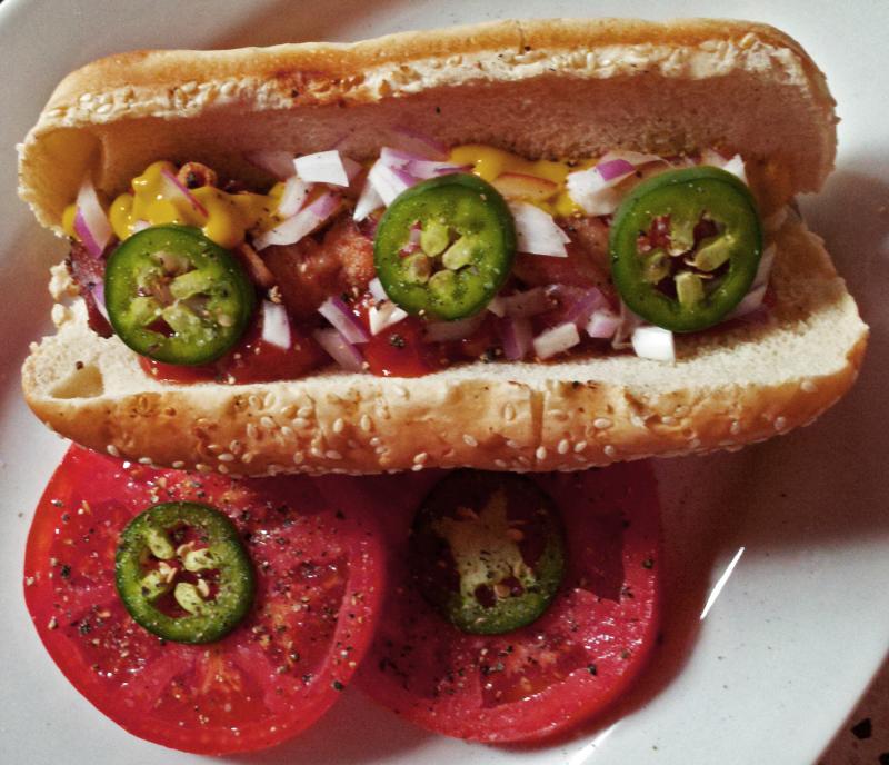 Discomfort from peppers can be balanced by comfort food. Take the Texas Tommy, for example: an all-beef dog wrapped in bacon and fried to a crisp, served on a toasted roll. Add some onions, fresh local jalapenos, and the comfort will be perfect. Add a couple of heirloom tomato slices and it becomes a healthy salad! BOB YESBEK PHOTO